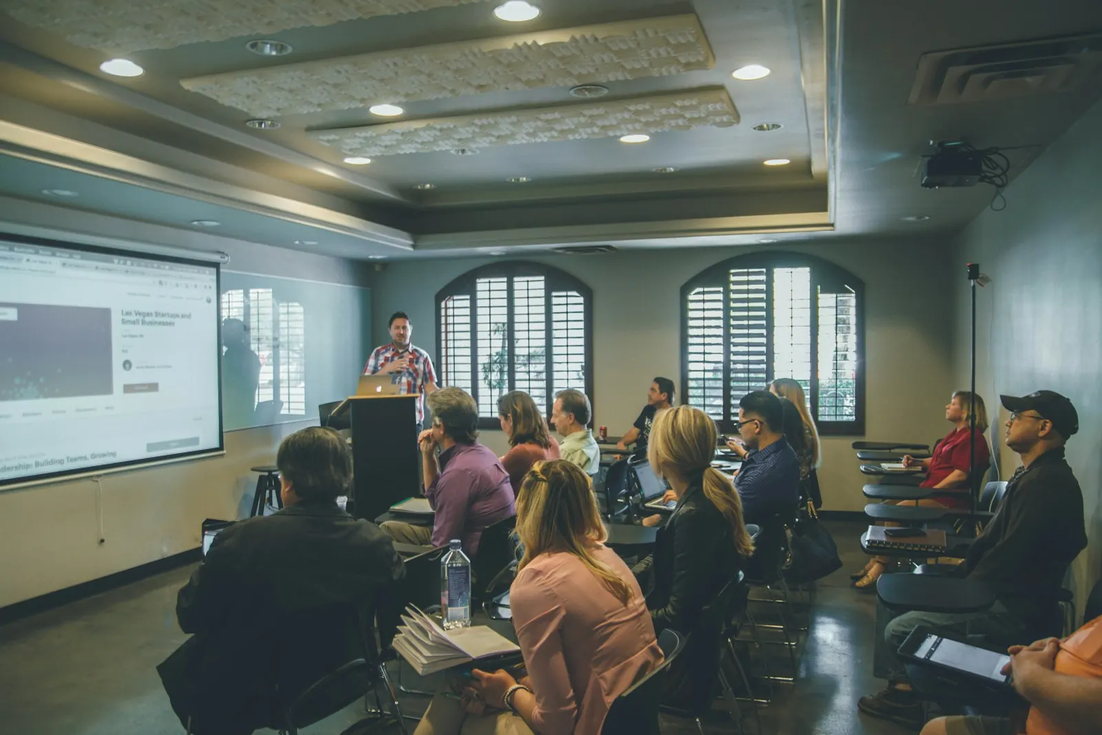 Adults attending a training workshop with a presentation on screen